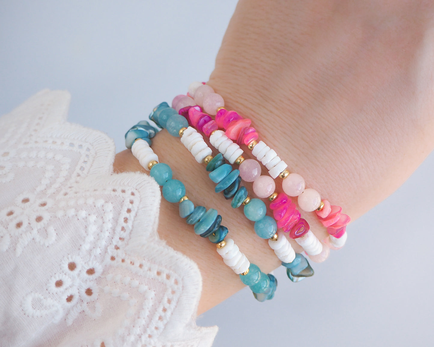Colorful beaded bracelets on a wrist with a light background