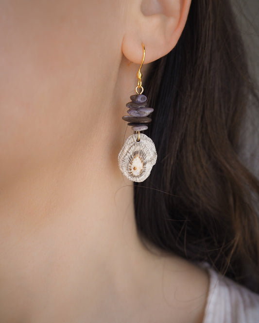 Model wearing gold hoop earring with shell and dark stones in ear. Gold Striped Limpet Shell Dark Grey Stone Drop Earrings. Gold hoops with real shells from Portugal. Made with 14k gold stainless steel hoop earrings.   