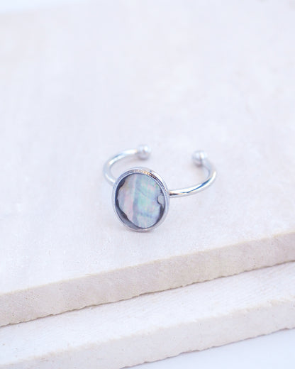 Close up of Silver ring with a piece of abalone shell on stone displayed. The piece of abalone shell was found on the beaches of Portugal. Set in a bezel ring made of silver stainless steel. The ring is adjustable. 
