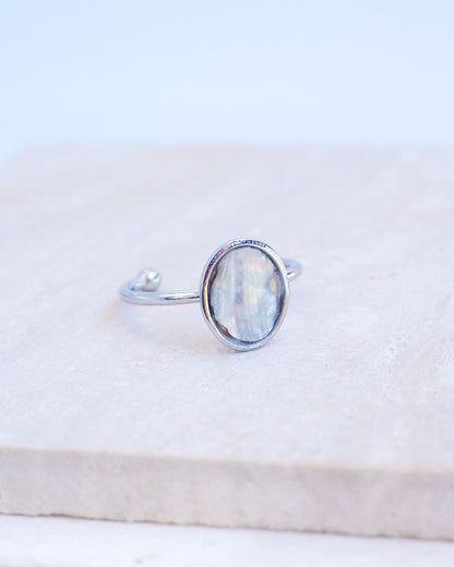 Side view of Silver ring with a piece of abalone shell on stone displayed. The piece of abalone shell was found on the beaches of Portugal. Set in a bezel ring made of silver stainless steel. The ring is adjustable. 