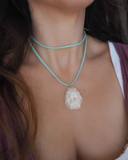 Model wearing a necklace with limpet shell pendant from Portugal and turquoise suede cord 