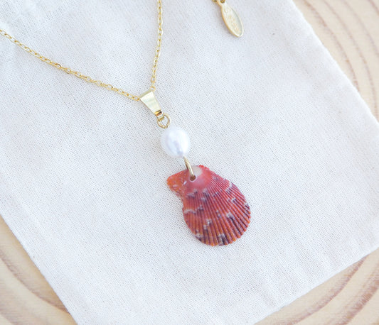 Tiny Red Orange Scallop Shell Pearl Necklace. Made with a handpicked scallop shell from Portugal and adorned with a ivory white freshwater pearl on cotton displayed. 
