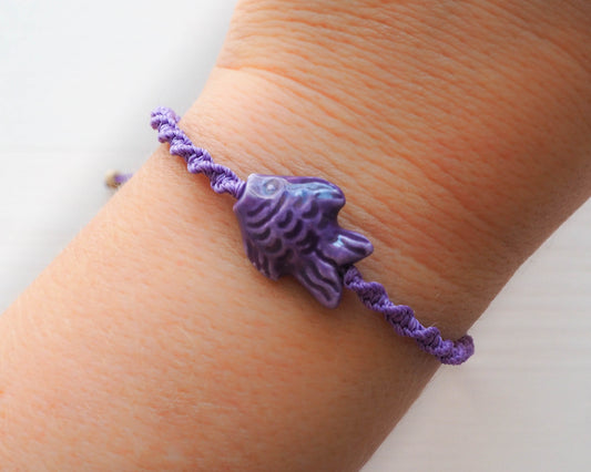 A photo displaying the entire Purple Fish Bracelet, elegantly worn on a wrist. The bracelet adds a touch of marine-inspired sophistication to the outfit.