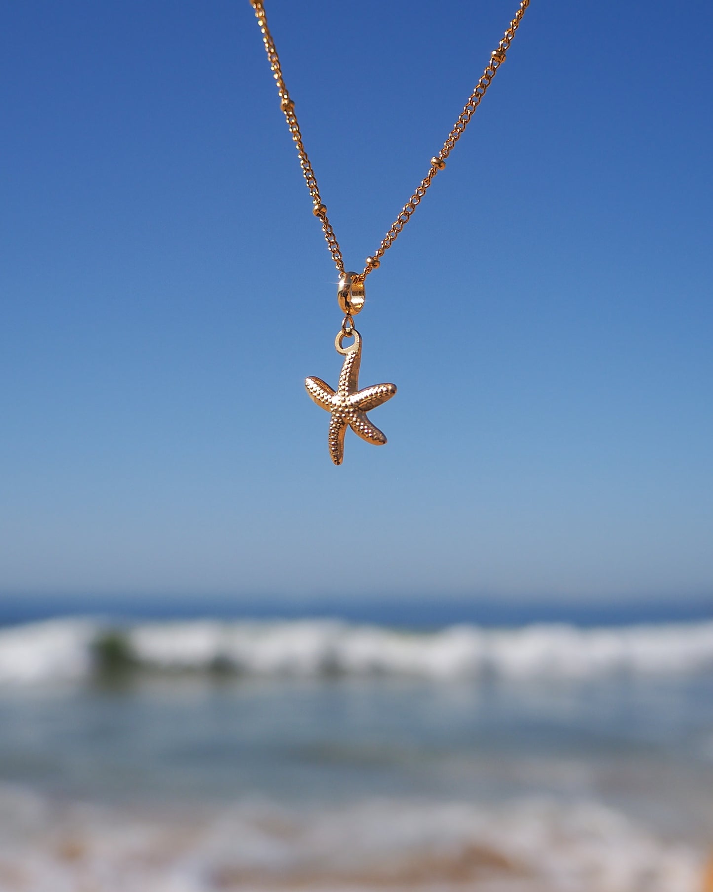 Gold Starfish Necklace with ocean background