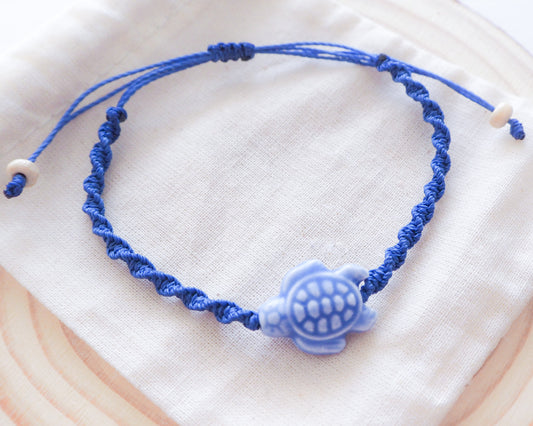 A close-up photo of the Deep Blue Ceramic Turtle centerpiece. The turtle is handcrafted with intricate detailing and glazed in vibrant deep blue, sea by lou, portugal jewelry