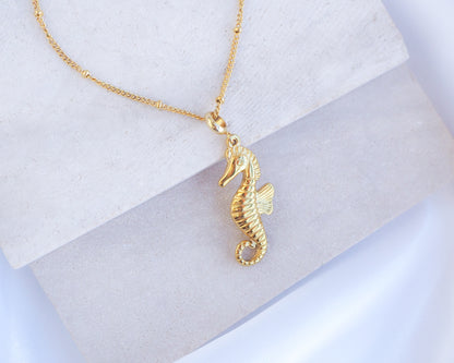 Close up of Gold Hippocampus Seahorse Necklace on stone displayed. Made with premium 18k gold stainless steel. Hippocampus pendant. Seahorse Jewelry, Sea by Lou, Seabylou