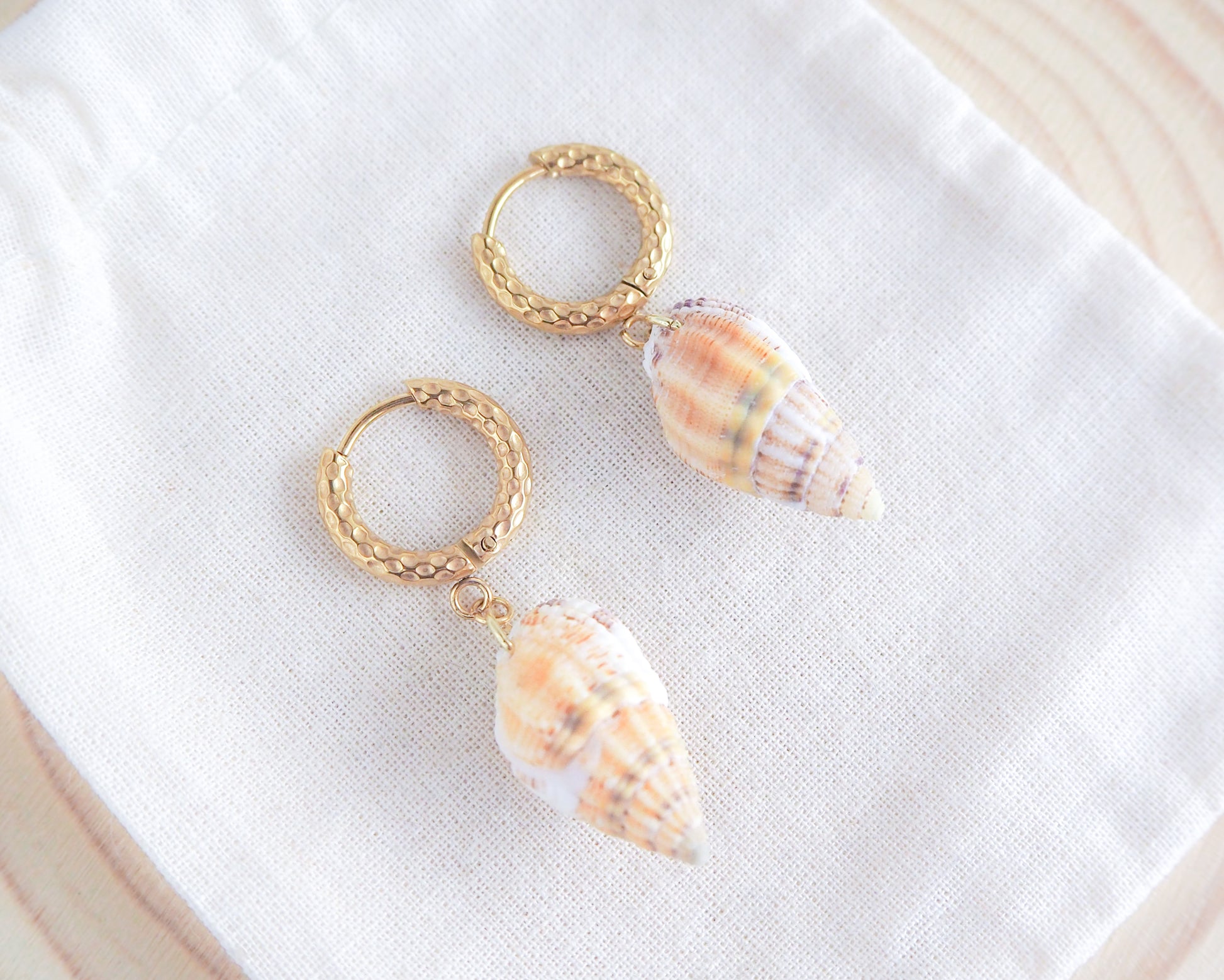 Gold Netted Dogwhelk Shell Earrings with Gold Hoop Hooks on display