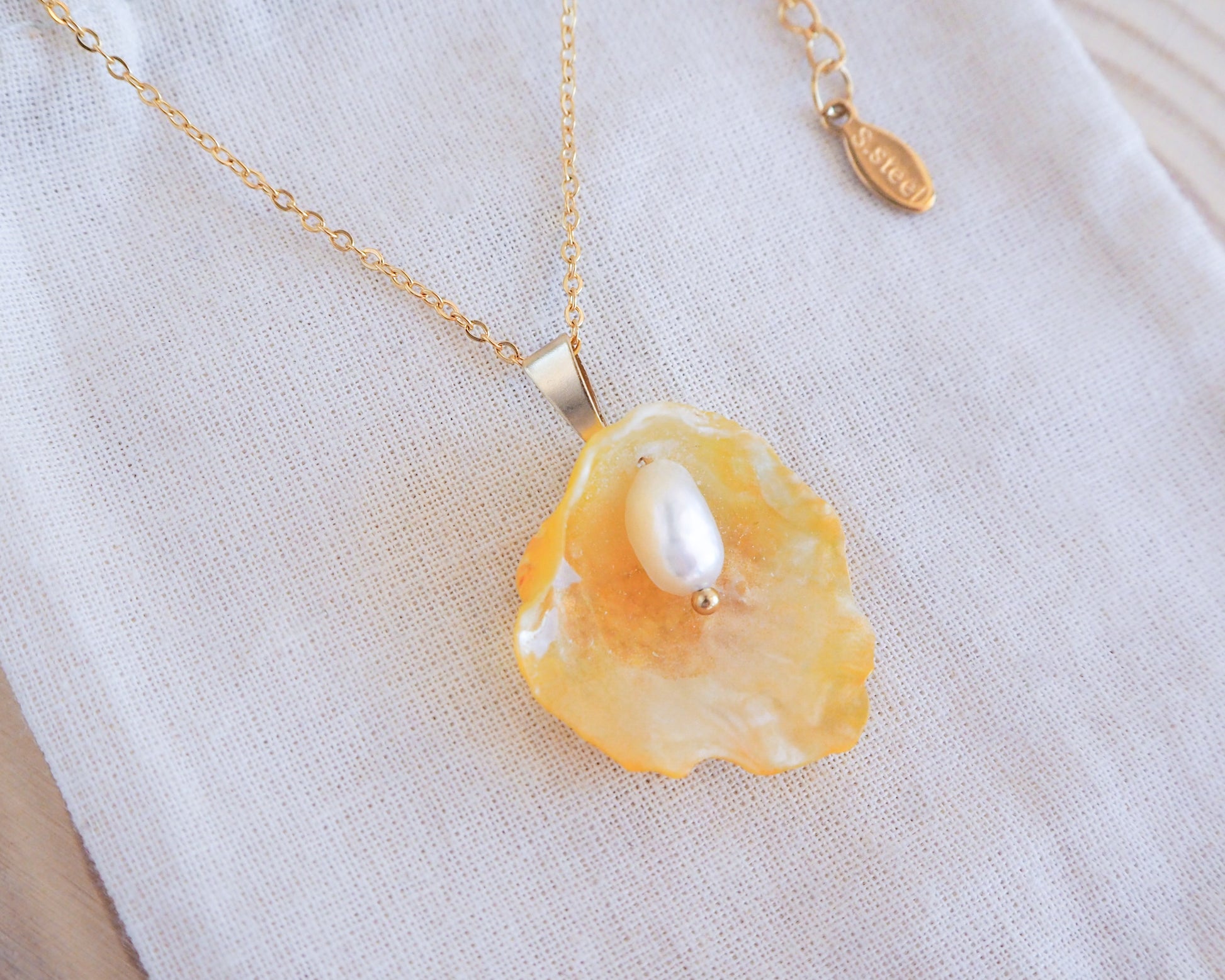 Gold Yellow Jingle Shell Necklace on display, Mother of Pearl Pendant