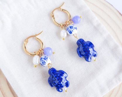 Gold Turtle Azulejo Tile Earrings with Gemstones and Freshwater Pearls on display