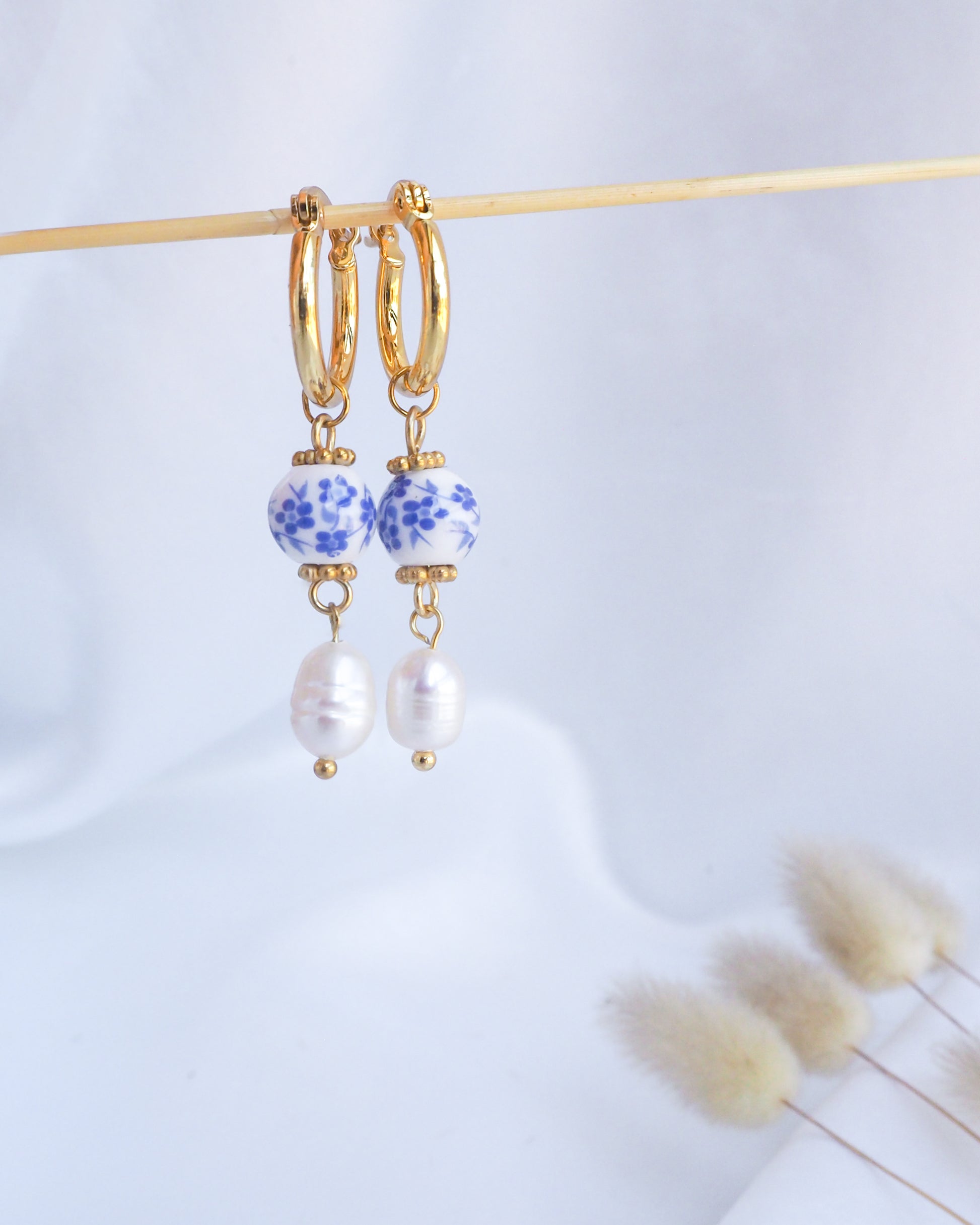 Gold hoop earrings with blue and white bead accents on a light background. Gold Ceramic Azulejo Pearl Earrings from Portugal, Portuguese Ceramic Tlle Jewelry