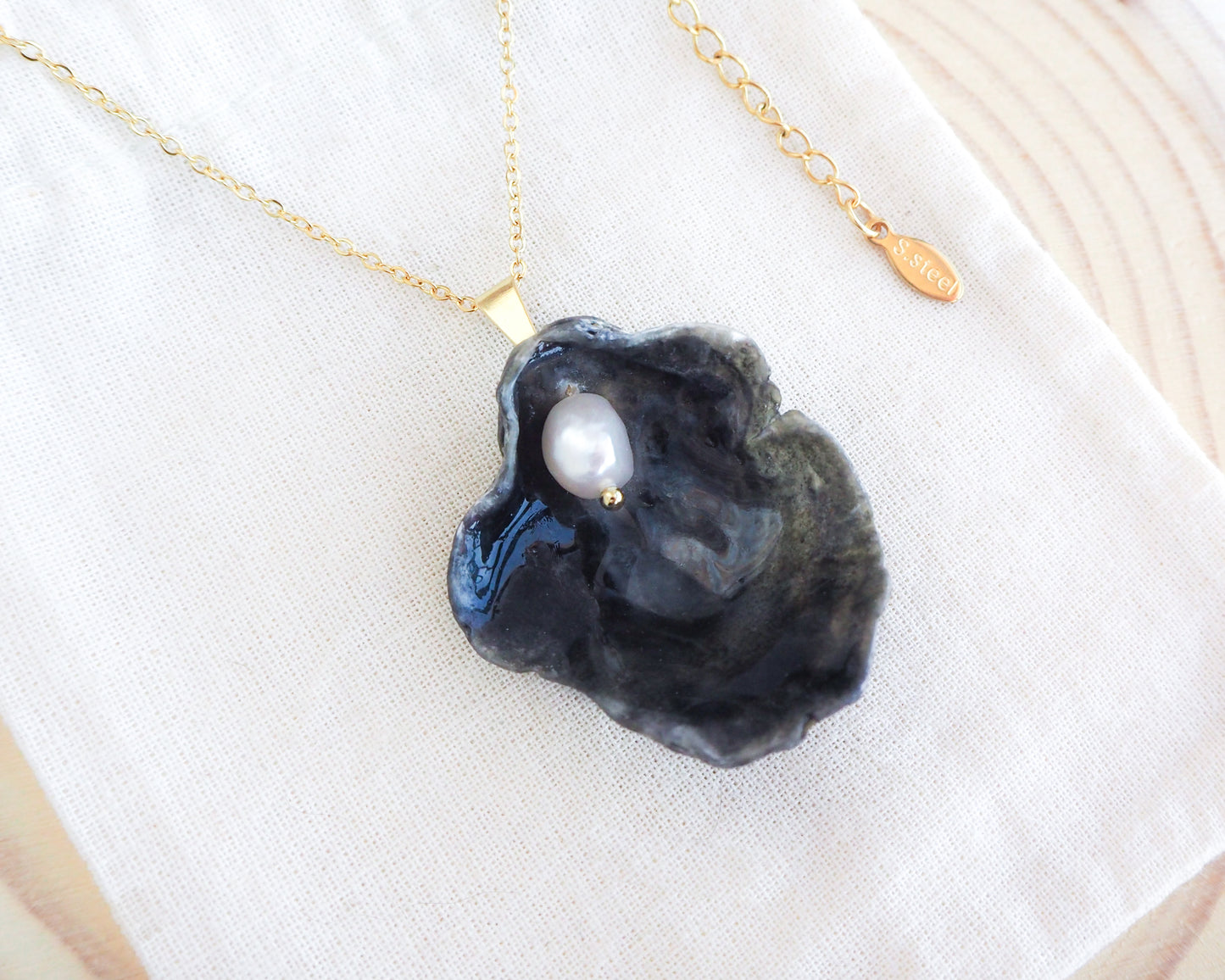 Gold Black Jingle Shell Necklace on display, Dark Mother of Pearl Pendant