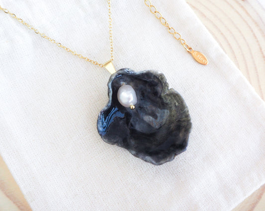 Gold Black Jingle Shell Necklace on display, Dark Mother of Pearl Pendant