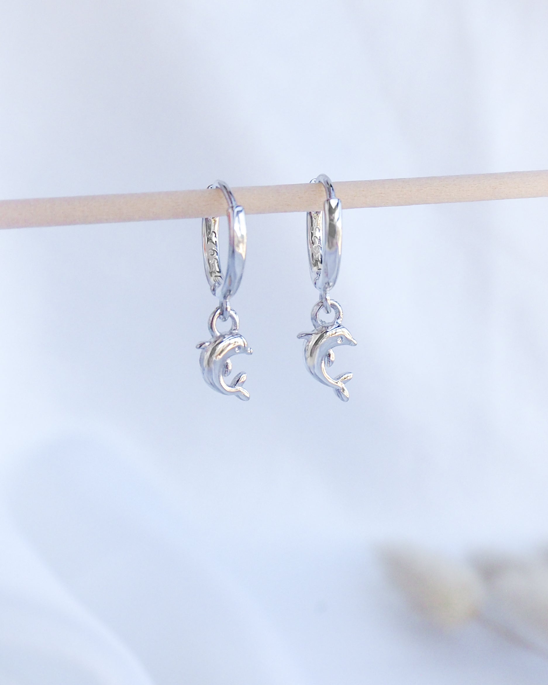 Silver Dolphin Earring Hoops. Front view of Silver Dolphin Earrings. Tiny dolphin pendants hoop earrings made of 925 sterling silver