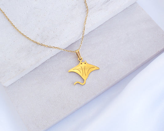 Gold Manta Ray Necklace on stone displayed. Made with premium 14k gold stainless steel. Tiny manta ray pendant