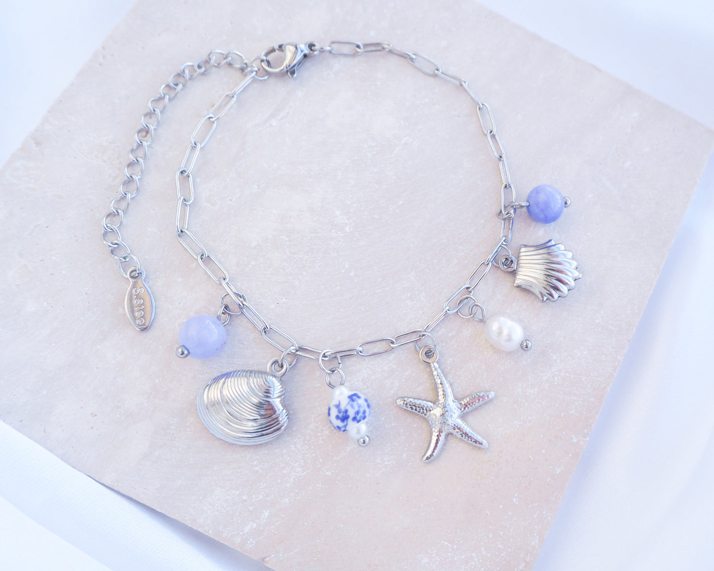 Close up of Silver Oceanic Charm Bracelet with Azulejo Tile Beads, Gemstones, Starfish, Sea Star and Shell pendants