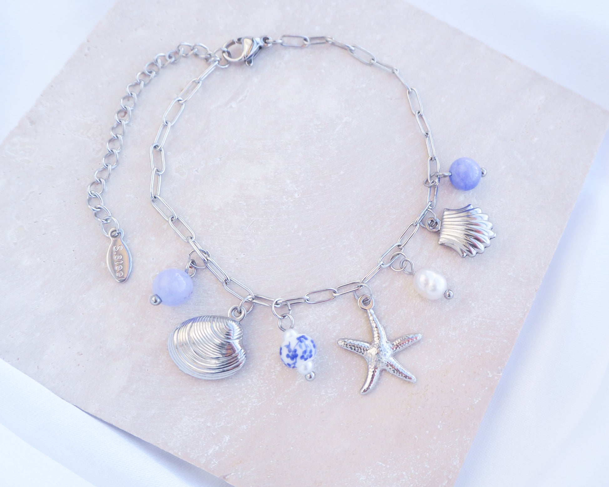 Close up of Silver Oceanic Charm Bracelet with Azulejo Tile Beads, Gemstones, Starfish, Sea Star and Shell pendants