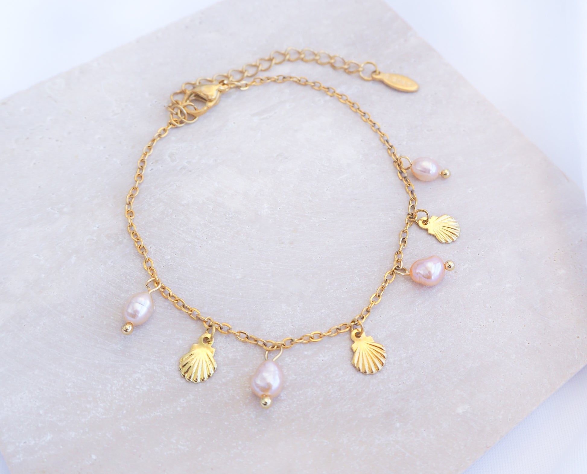 Gold Tiny Shell Rose Pink Freshwater Pearl Bracelet displayed on stone, Dainty Gold Shell Bracelet