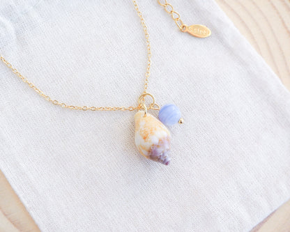 Tiny Light Rustic Dove with Angelite Gemstone Necklace displayed on stone