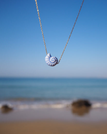 White Ceramic Seashell Nautilus Gold Necklace with ocean background of Portugal