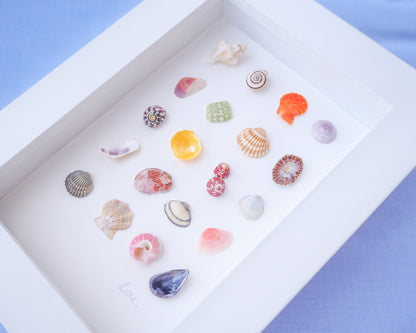 Close up of Seashell Artwork Mini Mix featuring 20 tiny beach treasures and shells handpicked from Portugal set in a white glass frame box. Coastal Beach Art for bookshelf and nightstand. seabylou, SEA by LOU
