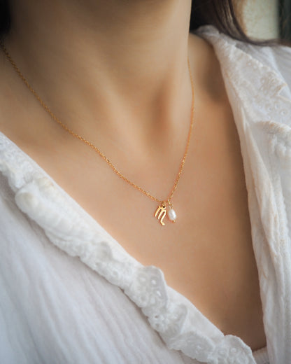 Model wearing Gold Scorpio Zodiac Pearl Necklace on neck with white blouse, made with 18k gold stainless steel and white freshwater pearl 