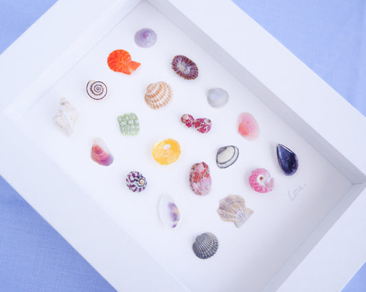 Side view of Seashell Artwork Mini Mix featuring 20 tiny beach treasures and shells handpicked from Portugal set in a white glass frame box. Coastal Beach Art for bookshelf and nightstand. seabylou, SEA by LOU
