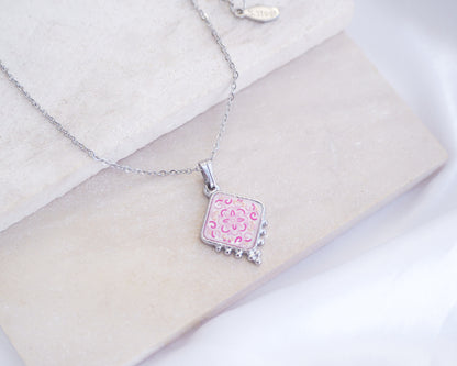 Close up of Portuguese Tile Necklace Floral Pink silver on stone displayed. Made with silver stainless steel and white pink floral pendant inspired by the Portuguese Azulejo design pattern. 