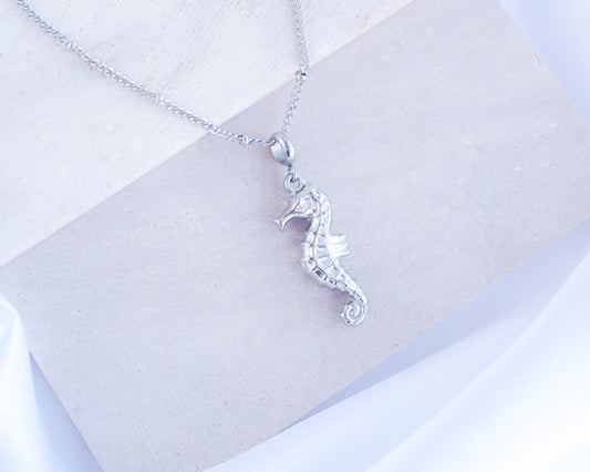 Silver Seahorse Necklace on stone