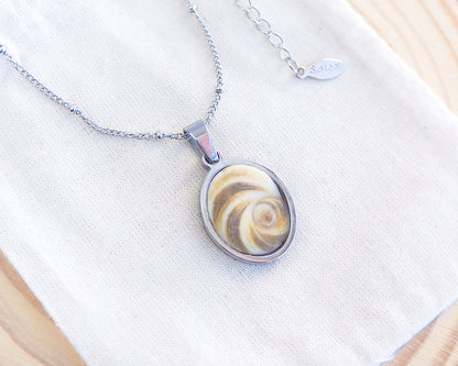 Khaki Green Eye of Saint Lucia Silver Necklace on cotton displayed, silver stainless steel shiva eye pendant necklace, Saint Lucy Eye, operculum pendant