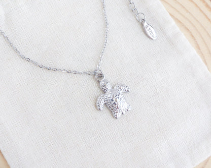 Silver turtle pendant necklace on a white background