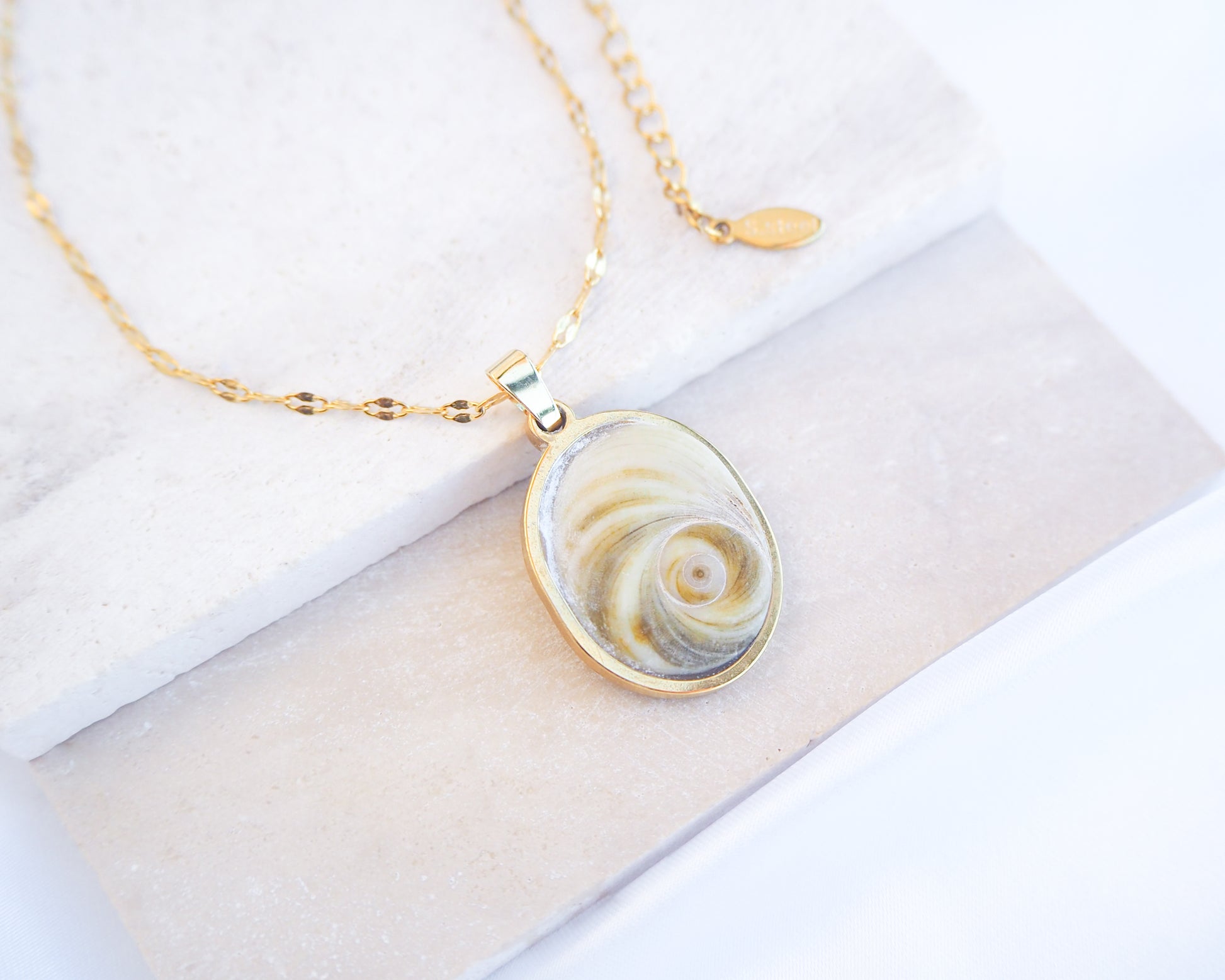 Soft Green Eye of Saint Lucia Gold Necklace on stone displayed, 18k gold stainless steel shiva eye pendant necklace, Saint Lucy Eye, operculum pendant