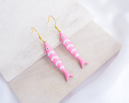 Pink Sardine Fish Gold Earrings on stone displayed