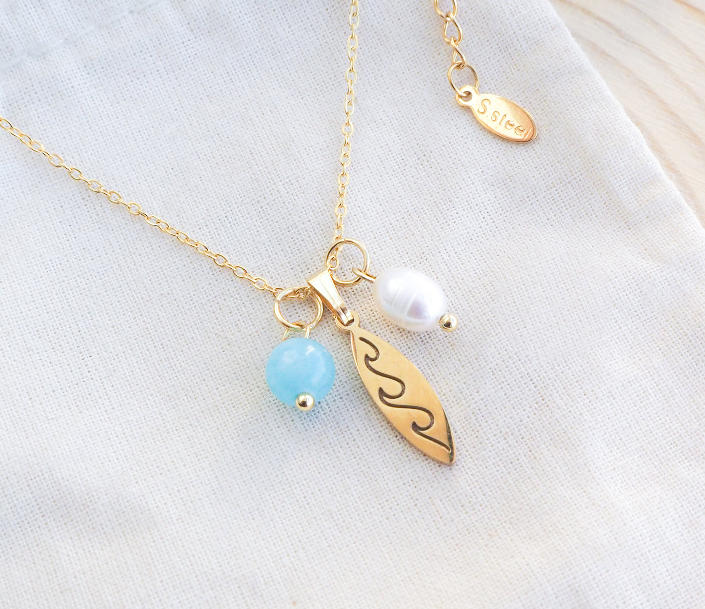 Surfboard Necklace Pearl and Aquamarine Beads on display
