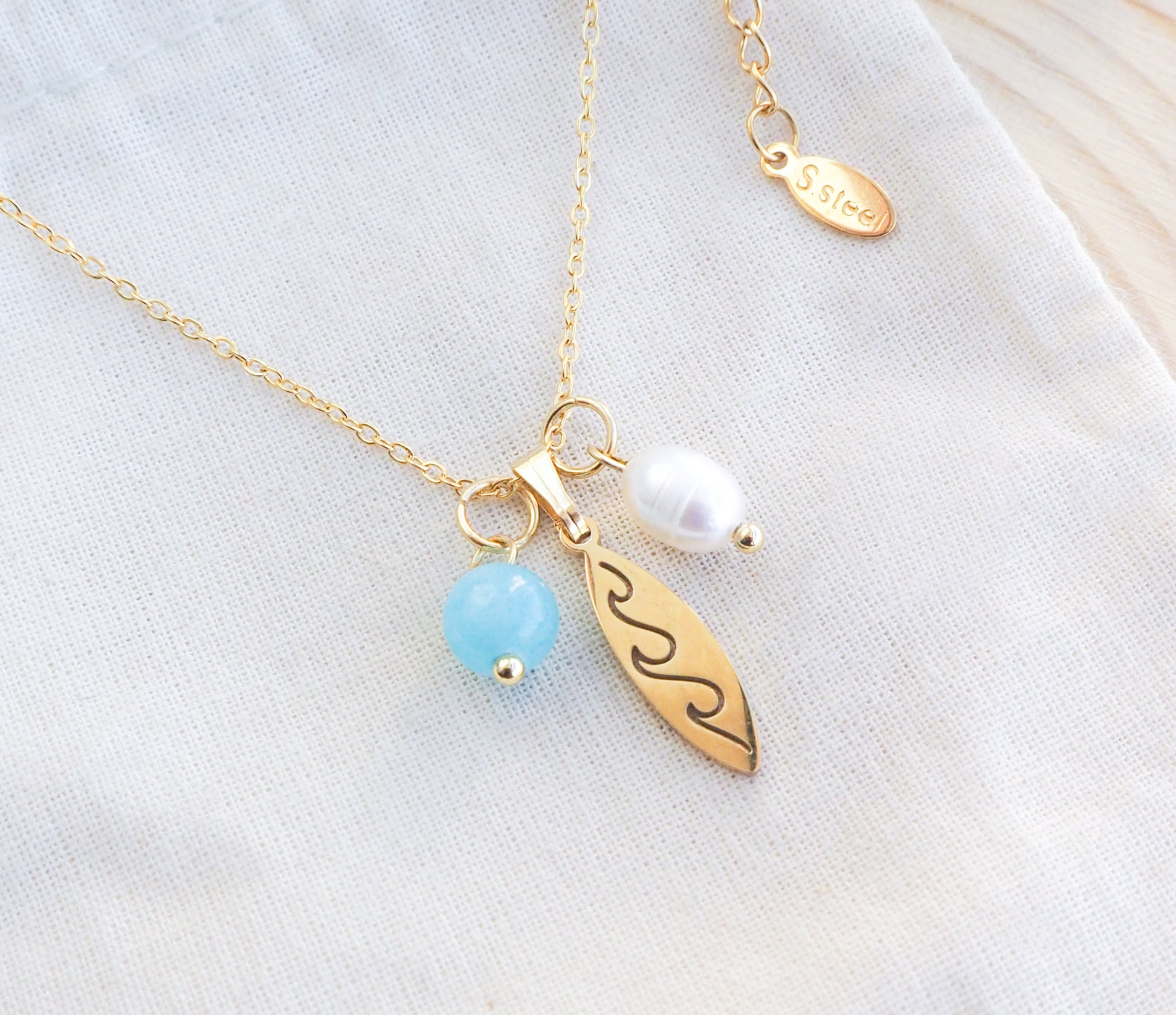 Surfboard Necklace Pearl and Aquamarine Beads on display