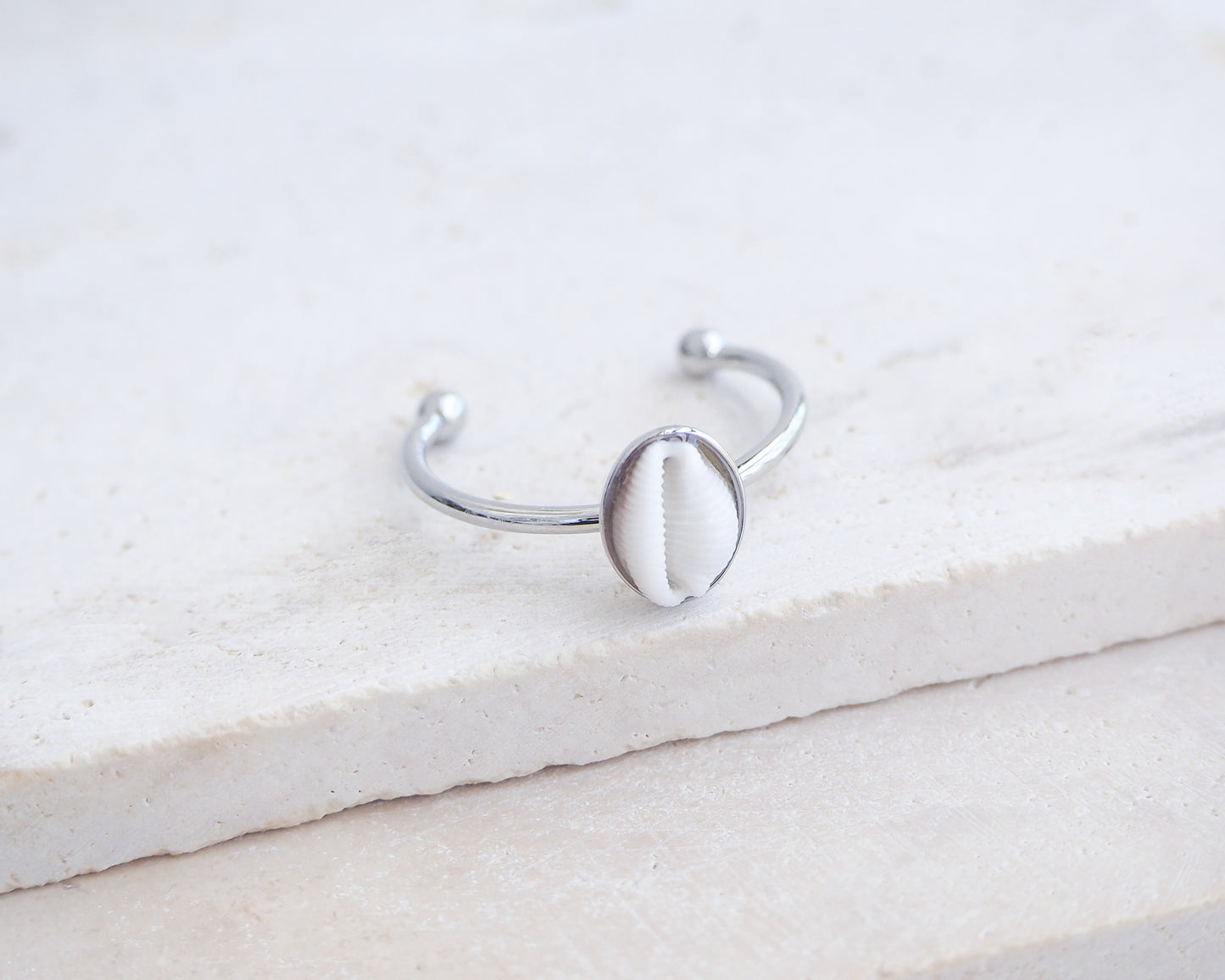 Side view of European Cowrie Shell Silver Ring from Portugal on stone display, Handpicked Spotted Cowrie Shell from Portugal, Silver Stainless Steel ring with tiny cowrie shell, Gift for beach girls