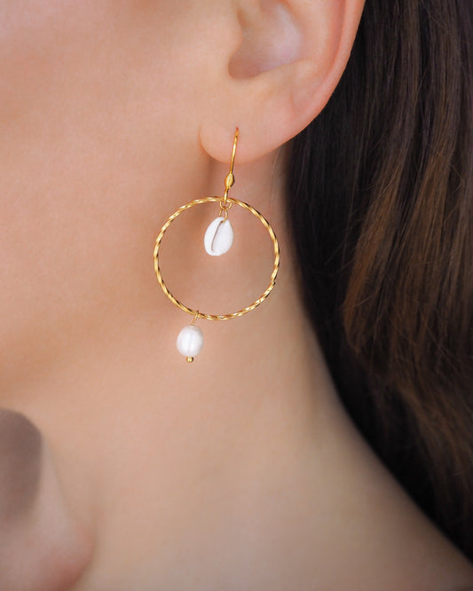 Model wearing Boho Chic Cowrie Shells Pearl Hoop Earrings in ear, 18k Gold Stainless Steel Hoop earrings with tiny cowrie shells handpicked from Portugal. Conchas Beijinhos, Ivory freshwater pearls, seabylou 