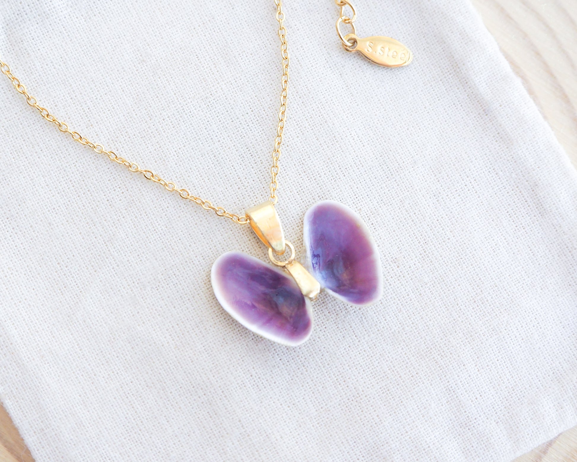 Tiny Purple Butterfly Shell Gold Necklace on display, Coquina Shells from Portugal