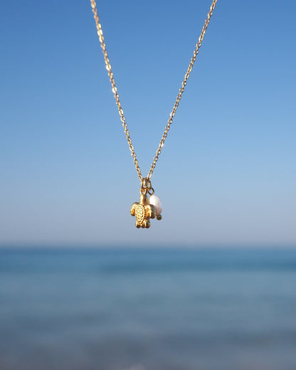 Close up of Tiny Turtle Pearl Necklace with ocean background, Gold Necklace with freshwater pearls and 18k gold turtle pendant, Minimalistic Ocean Inspired Jewelry, Jewelry for Beach Girls 