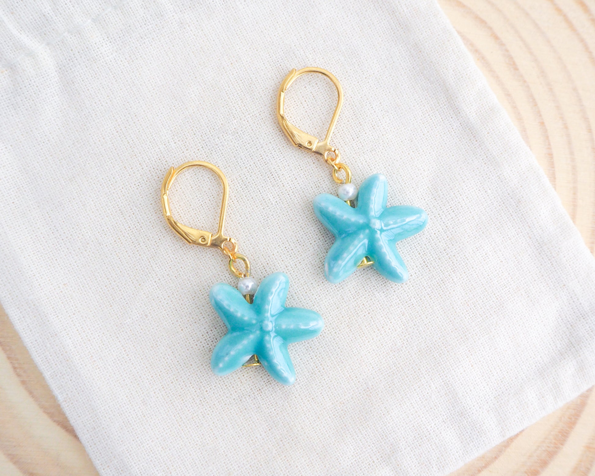 Turquoise Sea Star Starfish Ceramic Earrings on display