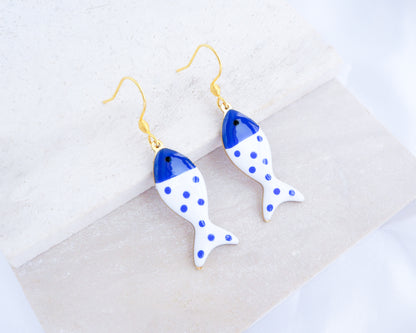 White Blue Polka Dot Sardine Fish Earrings  displayed on stone, 14k gold stainless steel earring hooks, summer drop earrings from Portugal