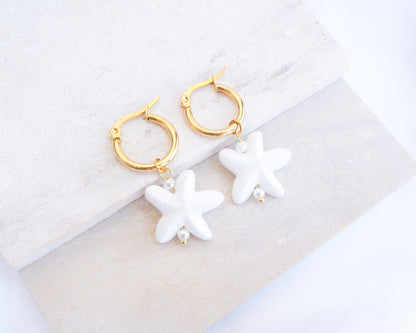 White Ceramic Starfish Gold Earrings on stone, 14k gold stainless steel hoops with white ceramic sea star pendants