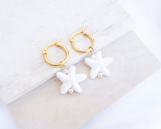 White Ceramic Starfish Gold Earrings on stone, 14k gold stainless steel hoops with white ceramic sea star pendants