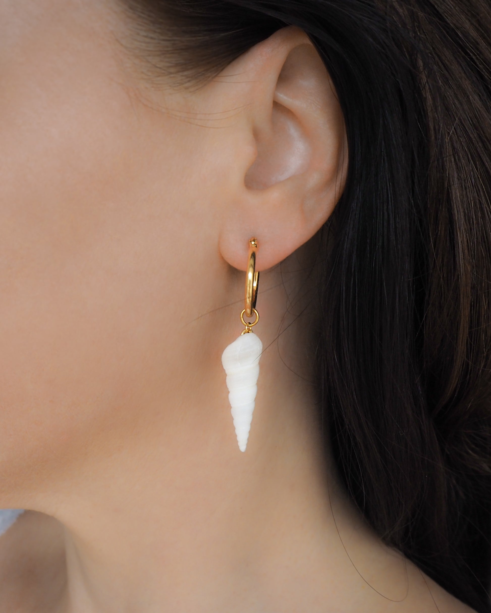 Model wearing White Common Tower Shell Gold Earring Hoops in ear, handpicked white tower shells from Portugal, 18k gold stainless steel shell earring hoops, seabylou 