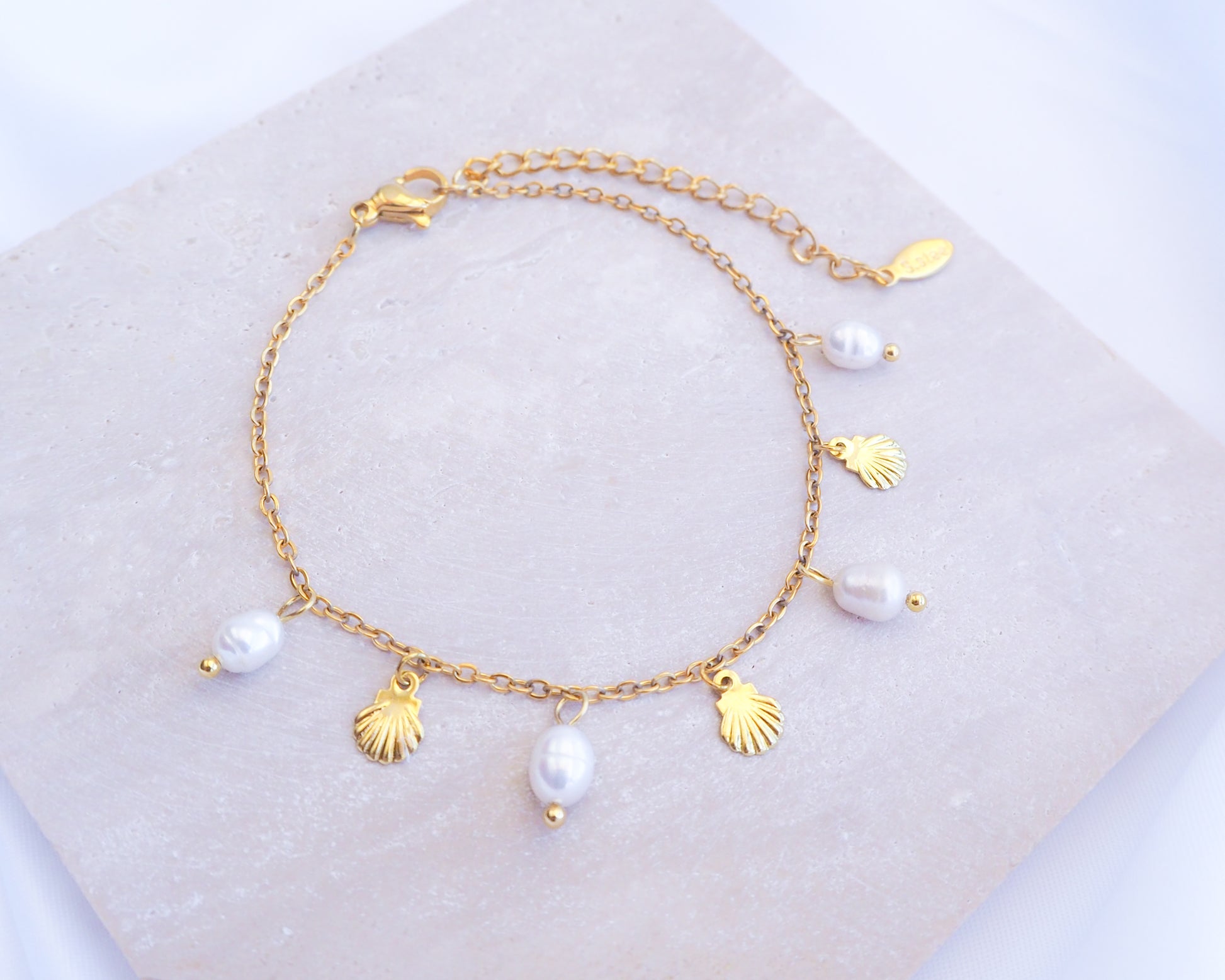 Gold Tiny Shell White Freshwater Pearl Bracelet displayed on stone, Dainty Gold Shell Bracelet