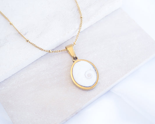 White Eye of Saint Lucia Gold Necklace on stone displayed, 18k gold stainless steel shiva eye pendant necklace, Saint Lucy Eye, operculum pendant