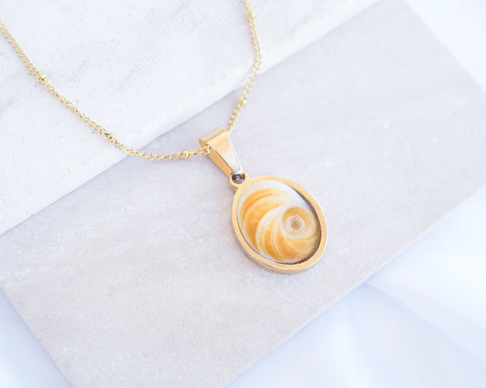 Yellow Orange Eye of Saint Lucia Gold Necklace on stone displayed, 18k gold stainless steel shiva Yellow Orange eye pendant necklace, Saint Lucy Eye, operculum pendant